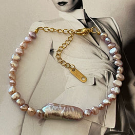 Pulsera Hippie Chic de elegantes perlas de agua dulce en suaves tonos lilas azulados y base de acero inoxidable dorado.