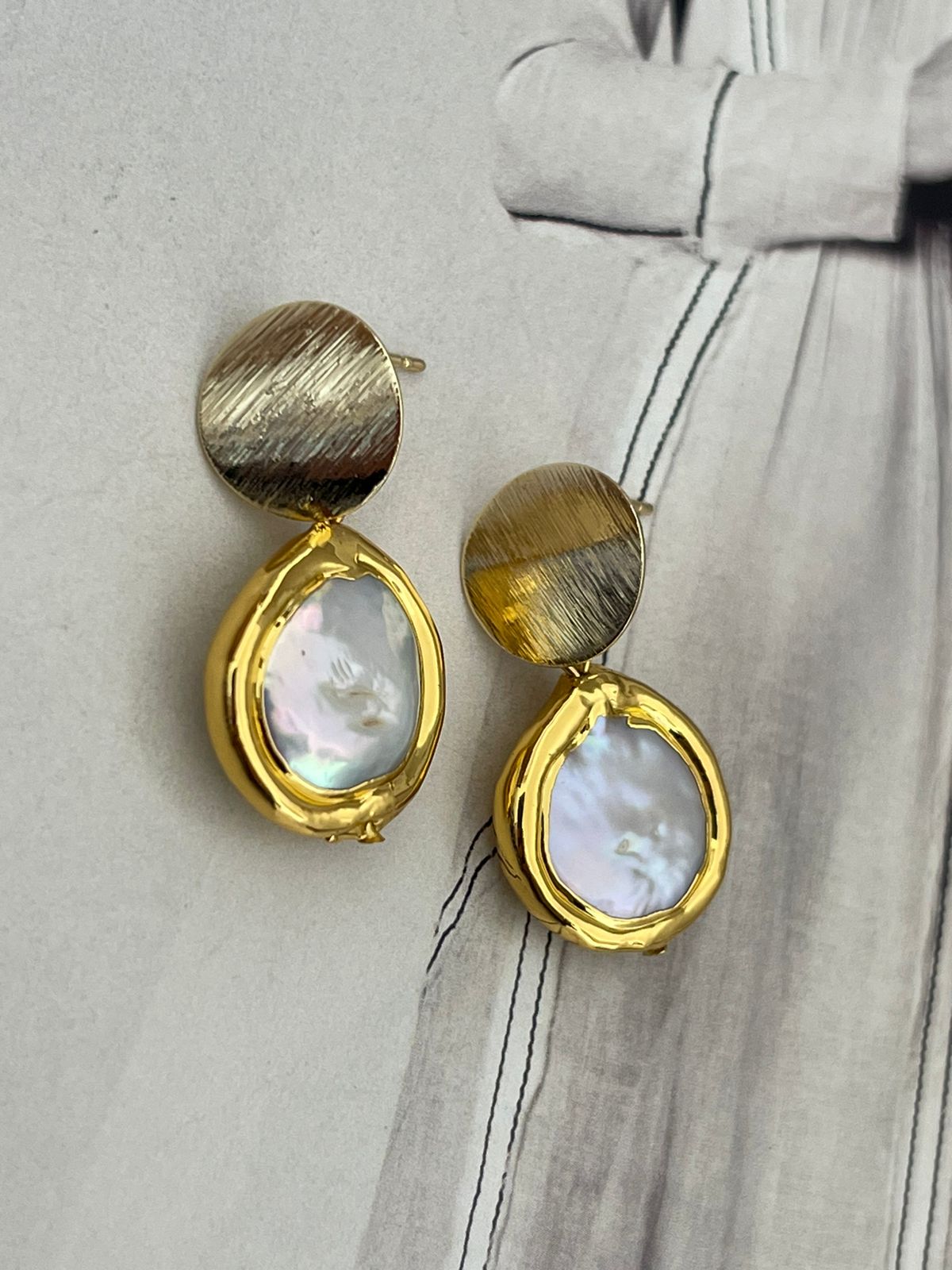 Aros Hippie Chic bañados en oro con elegante perla barroca blanca y borde dorado.