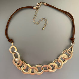 Collar Hippie Chic corto con finos eslabones en dorado opaco y base de cuerda marron