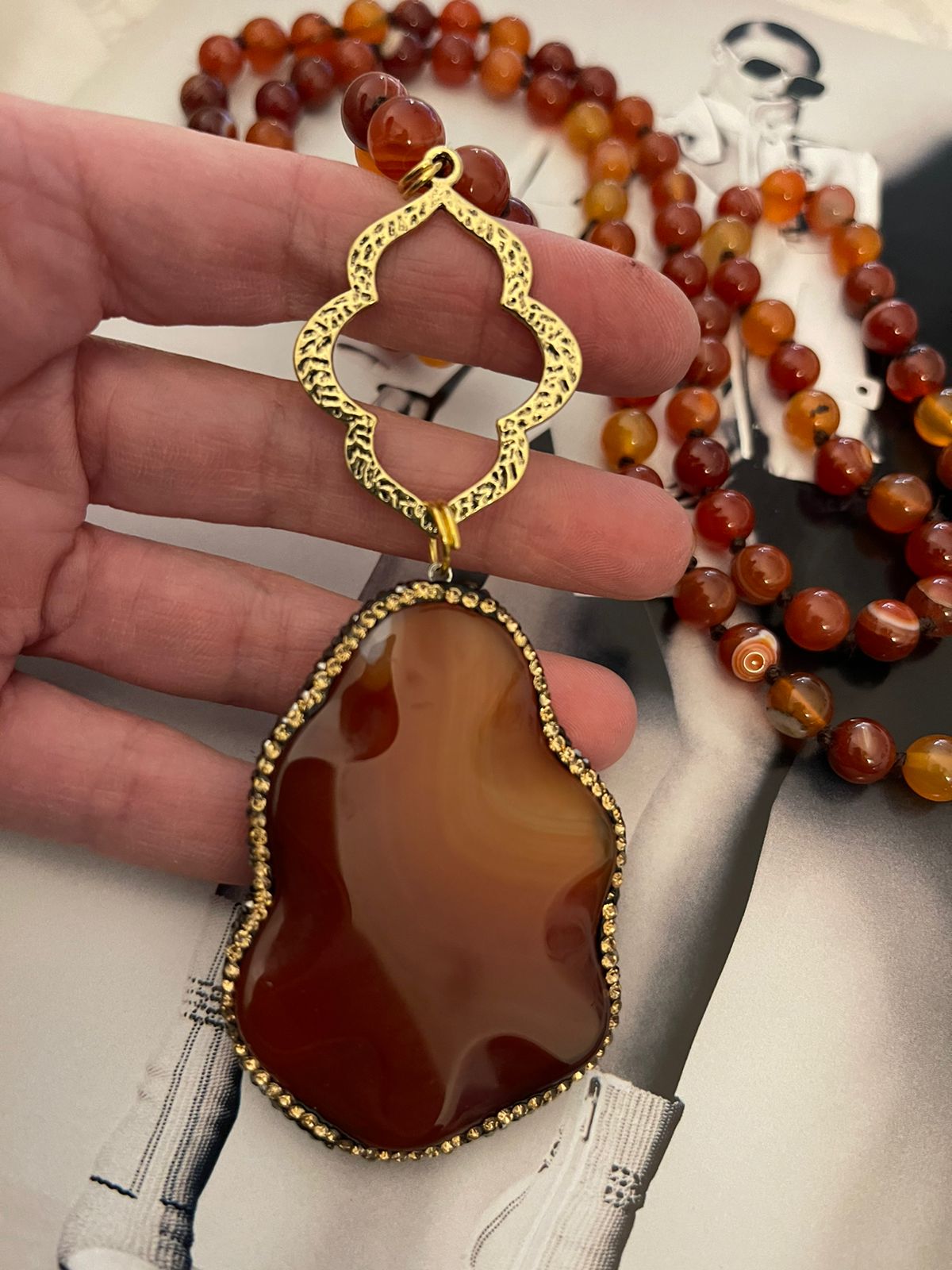 Collar Hippie Chic largo con preciosas piedras naturales rojas anaranjadas con colgante en los tonos y detalles de Pave dorados y negros.
