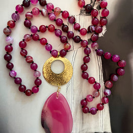 Collar Hippie Chic largo en alegres piedras Onix en color fucsia y base dorada.