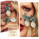 Aros Hippie Chic de acero inoxidable plateado con cristales azules en racimo y perla barroca.