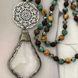 Collar Hippie Chic de piedras y cristales anudados en tonos verdes marrón con colgante de cristal en base plateada.