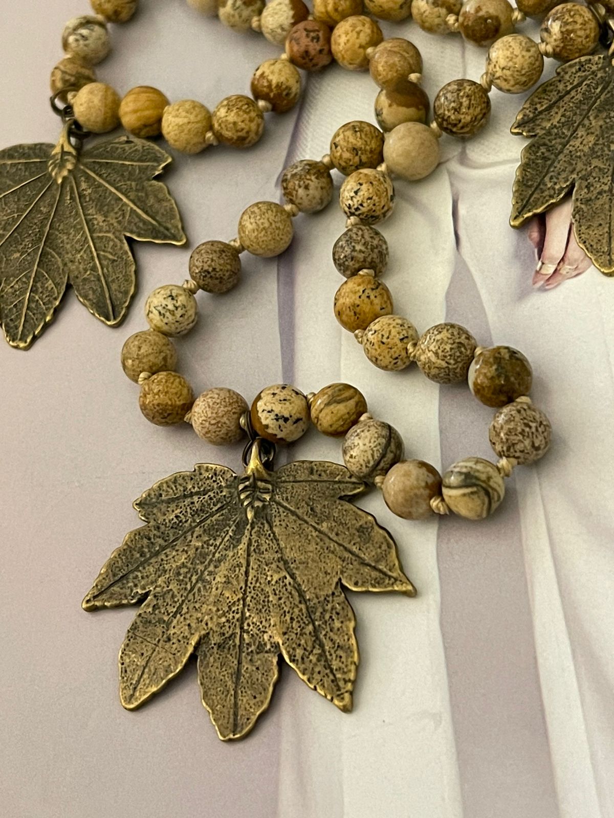 Collar Hippie Chic de piedras tonos tierra opacas anudadas con colgante de hojas dorado envejecido.